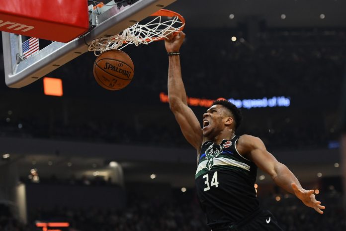 Giannis Antetokounmpo reacts to his dunk off the backboard